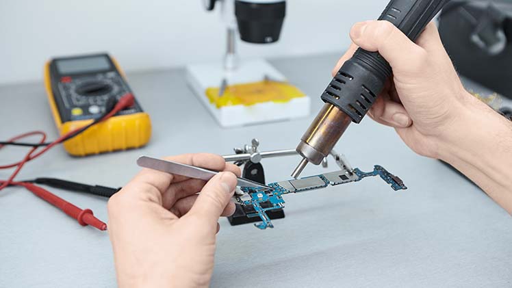 repairman-soldering-components-motherboard-while-fixing-damaged-smart-phone-using-tweezers-iron